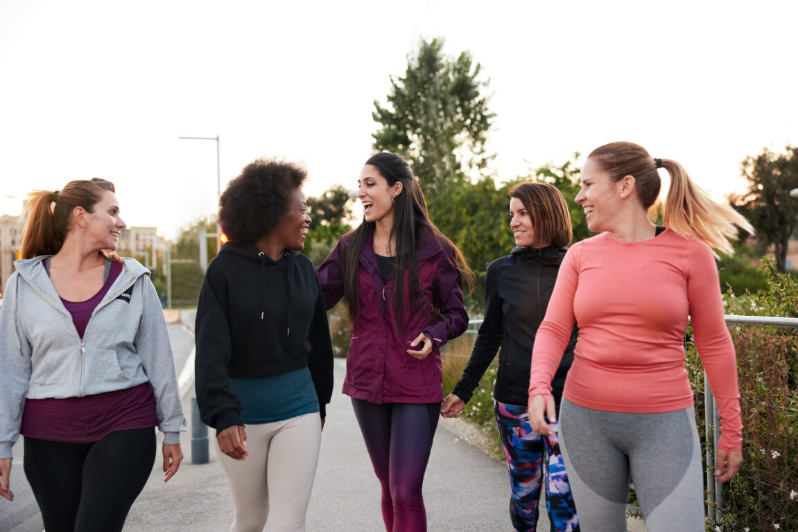 A group of women walking and talking after doing some outdoor exercise.