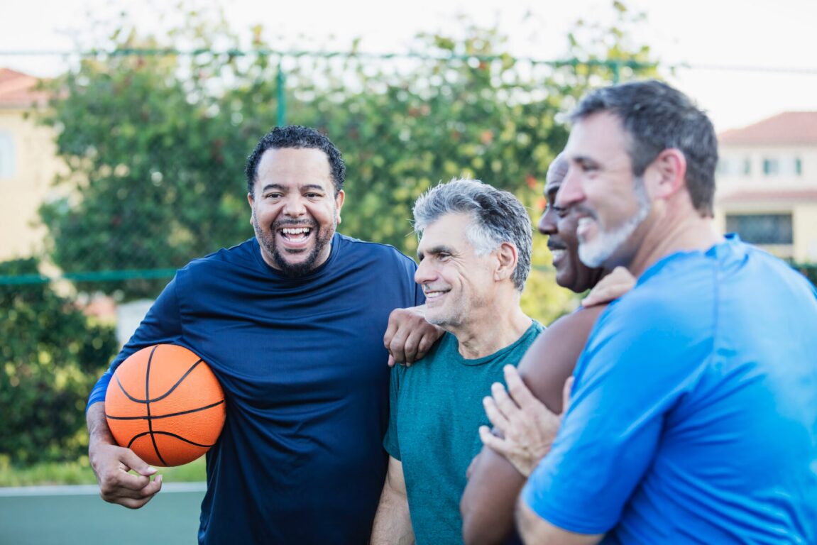 Multi-ethnic group of middle aged men playing basketball